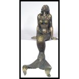 A bronzed effect cast metal large recumbent mermaid, in a seated position. Measures 45 cm high.