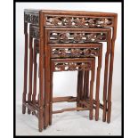 An early 20th century hardwood nest of four tables quartet. Raised on circular legs with