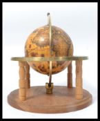 A vintage 20th century antique style desk top zodiac globe raised on a wooden circular base with