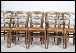 A set of 10 French provincial oak ladderback dining chairs being raised on serpentine legs with