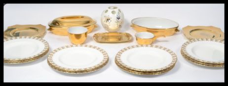 A set of 12 Royal Crown Derby dinner plates having a gilt painted rim and panel design along with