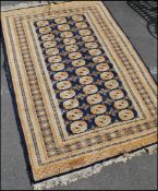 An early 20th Century floor rug / carpet of Persian design, central blue ground panel with beige