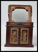 An early 20th century Chinese lacquered shaving mirror box form cabinet having a swivel and raise