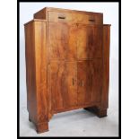 A 1930's Art Deco walnut cocktail cabinet having a fall front drinks cabinet set over a cupboard