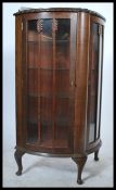 A 1930's Art Deco oak demi - lune china display cabinet. Raised on cabriole legs with a half moon