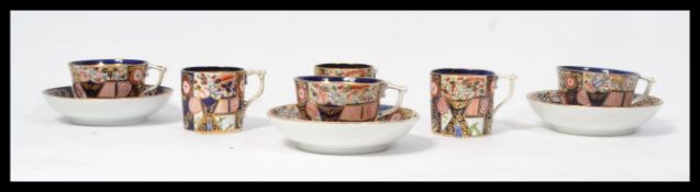 An early 19th century Derby c1806-1825 group of three Imari pattern cups and saucers along with