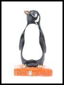 A Royal Doulton figure of a Penguin standing on a book titled "Best Wishes" Penguin books figurine