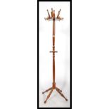 A vintage 20th century antique style hat coat stand of unusual form with bobbin turned legs supports