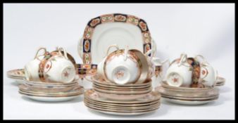 An early 20th century Royal Albert tea service in an Imari pattern consisting of cups , saucers ,