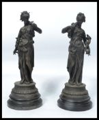 A pair of 19th century classical spelter figurines, each with maiden playing musical instruments