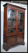 An early 19th Century Edwardian mahogany bookcase cabinet, two long glazed doors over two short