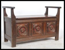 An early 20th century provincial oak Brittany hall settle bench with pierced cartwheel decoration,
