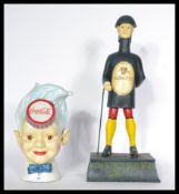 A pair of cast metal advertising money boxes for Coca Cola of a boy with Cola bottle cap to head a