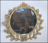 A 20th Century ornate moulded gilt swag detailed mirror, decorated profusely with moulded plaster