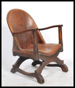 An Early 20th Century Art Deco leather backed X framed tub chair with impressed armorial crest to