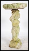 A 20th century reconstitued stone bird bath. The plinth stand in the form of a cherub - putti having