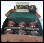 A leather cased set of early 20th century Crown Lawn wooden Lignum Vitae bowls. Stamped with