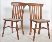 A pair of 19th century Victorian beech and elm windsor dining chairs raised on turned legs with