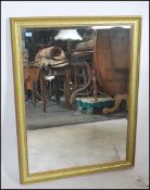 A large contemporary bevelled edge wall mirror having gilded and verdigris coloured frame, mirror to