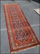 A vintage early 20th century Persian / Islamic long runner rug carpet of woolen construction