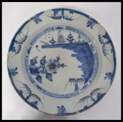 A mid 18th century English Delft pottery plate having hand painted blue and white decoration with