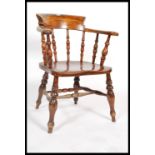 A 19th century elm and beechwood smokers bow elbow chair with turned spindle back, saddle shaped