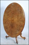 A 19th century Victorian burr walnut oval loo / breakfast tilt top dining table. Raised on splayed