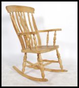 An antique style beech wood Windsor style lathe back rocking chair. Raised on turned legs on