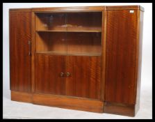 A large mid century walnut breakfront library bookcase having  a breakfront centre with glass
