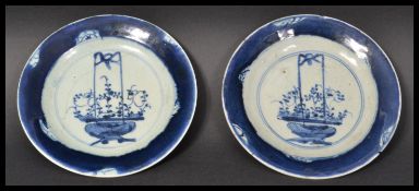 A pair of 18th century Chinese blue and white hand painted plates having blue borders with central