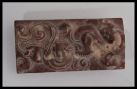 A Chinese red jade carved double sided bi panel hand carved with dragons and scrolls. Measures 6