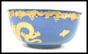 An early 20th century Bisto ware ceramic bowl having a deep blue ground with gilt decoration with