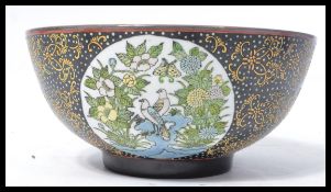 A 19th century Chinese ceramic bowl of large form having a black ground with gilt detailing and