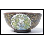 A 19th century Chinese ceramic bowl of large form having a black ground with gilt detailing and