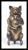 An early 20th century brass vesta case in the form of a greedy pig holding a bag of cash. Hinged lid
