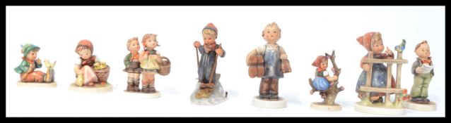 A collection of eight 20th Century ceramic figures of children in various poses by Hummel all