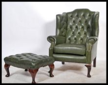 An Antique Chesterfield Style mahogany and leather button back armchair being raised on cabriole