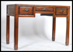 A Chinese 20th century-style elm scholars desk with three short frieze drawers, raised on square