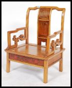 A 20th century Chinese hardwood low zen type chair having shaped scrolled arms with pictorial back