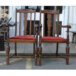 A pair of 1920's solid oak carver armchairs - dining chairs. raised on block legs with cup and cover