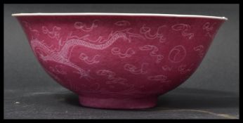 A 19th century Chinese bowl having a pink glaze depicting dragons chasing the flaming pearl.