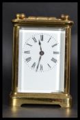 An early 20th century brass carriage clock with inset brass movement. Enamel face with roman numeral