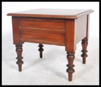 A Victorian 19th century mahogany commode being raised on turned legs with box body having hinged
