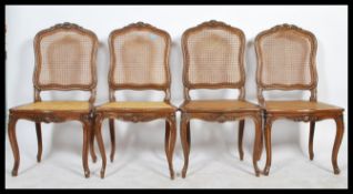 A set of 4 early 20th century walnut French bergere caned dining chairs. Raised on shaped legs