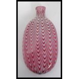 A Victorian 19th century Nailsea glass flat oval bottle in cranberry with white spiralling twist