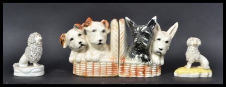 A pair of 19th Century Staffordshire figures modelled as Poodles together with a pair of ceramic