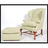 An antique style large Georgian revival wingback armchair and footstool ottoman, Both upholstered in