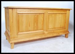 A 20th century large pine blanket box hinged lid to top with fitted sliding storage raised on square