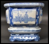 A 20th century Chinese jardiniere plant stand with blue and white decoration with geometric panels