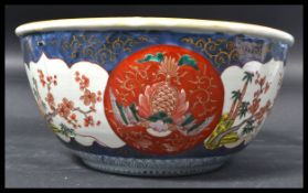 A 19th century Chinese bowl in an Imari pattern decorated with carp fish with gilt detailing. Four